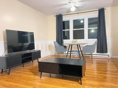 a living room with a television and a table with chairs at Premium convenient stays in Manchester