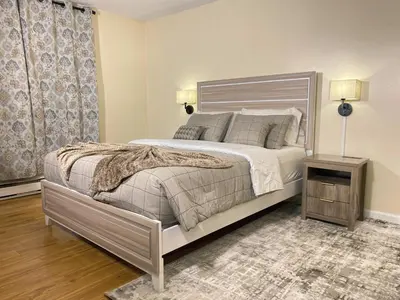 a bedroom with a large bed and a night stand at Premium convenient stays in Manchester