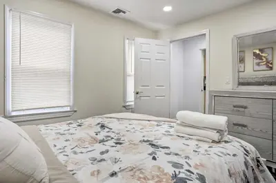 a bedroom with a large bed with a floral blanket at Charming Mamaroneck with 3BR and 3BA 22 Mi to Manhattan in Mamaroneck