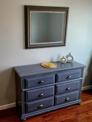 a blue dresser with a mirror on a wall at Spacious Apt in Fairview NJ Easy Commute to NYC with parking in Fairview
