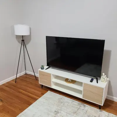a flat screen tv sitting on a white entertainment center at Spacious Apt in Fairview NJ Easy Commute to NYC with parking in Fairview