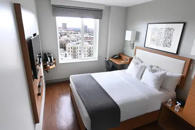 a hotel room with a bed and a window at Edge Hotel Washington Heights in New York