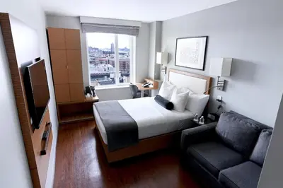a hotel room with a bed and a couch at Edge Hotel Washington Heights in New York