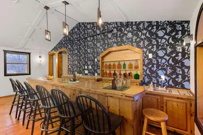 a bar with a bunch of chairs around it at The Mahogany Villa Indoor pool Spa Sauna Gameroom in Dover
