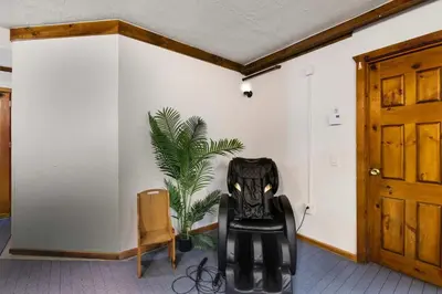 a black chair in a room with a plant at The Mahogany Villa Indoor pool Spa Sauna Gameroom in Dover