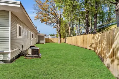 a fence next to a house with a yard at The Main Lineup 2 - All Star Baseball Rentals in Oneonta