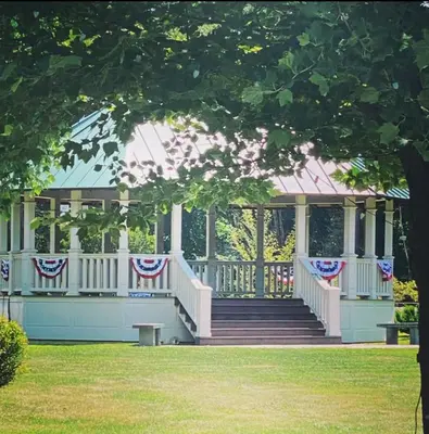 a gazebo with american flags and stairs in a park at Smith's Colonial Motel in Hancock