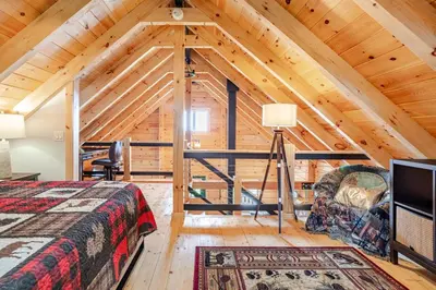 a log cabin bedroom with a bed and a tv at The Greylock Cabin in Florida
