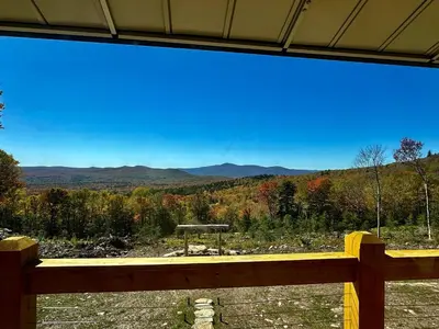 a wooden bench with a view of the mountains at The Greylock Cabin in Florida
