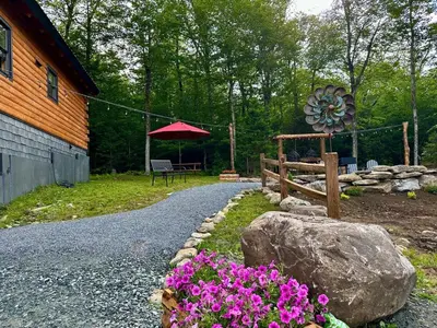 a garden with a bench and a rock and flowers at The Greylock Cabin in Florida