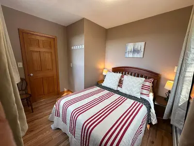 a bedroom with a bed with a striped blanket at Charlemont Chalet - A 15 Acre Private Retreat in Charlemont