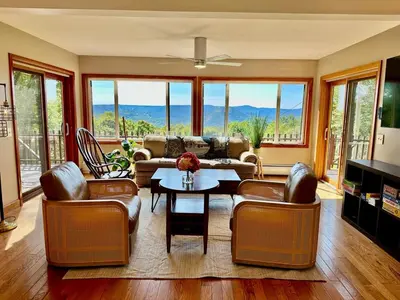 a living room with a couch and a table and chairs at Charlemont Chalet - A 15 Acre Private Retreat in Charlemont