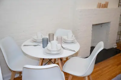 a white table with white chairs and a fireplace at Stylish East Village Apartment12 close to Union Square Steps from NYC Best Restaurants & Shops in New York