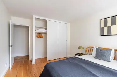 a white bedroom with a bed and a closet at Blueground Midtown East view nr UN Plaza NYC-2114 in New York