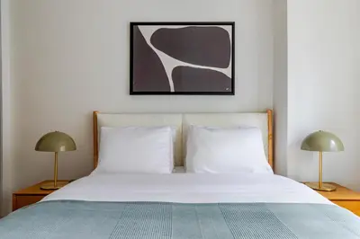 a bedroom with a bed with white sheets and two lamps at Blueground Midtown East view nr UN Plaza NYC-2114 in New York