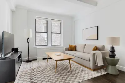 a living room with a couch and a table at Blueground Lincoln Square fitness nr Central Park NYC-2102 in New York