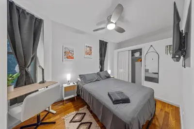 a bedroom with a bed and a desk and a window at The Global Nook - Private Room with Shared Bathroom near Times Square in New York