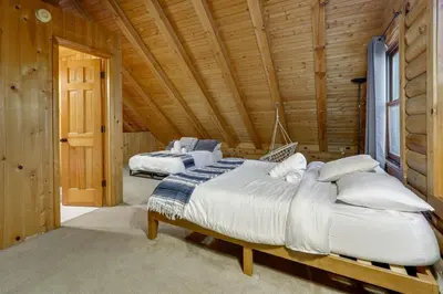 a bedroom with two beds in a wooden cabin at Year-Round Outdoor Adventures Poconos Hideaway in East Stroudsburg