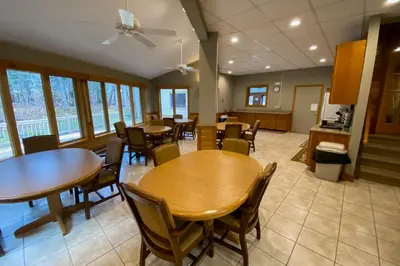 a dining room with tables and chairs and windows at Timber Creek #100 in Dover