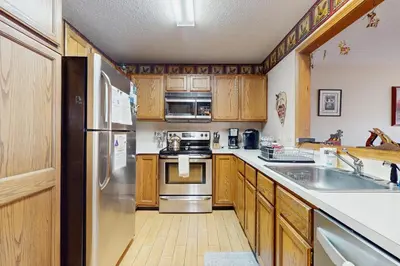 a kitchen with wooden cabinets and stainless steel appliances at Timber Creek #100 in Dover