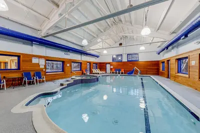 a large indoor pool with blue chairs and tables at Timber Creek #100 in Dover