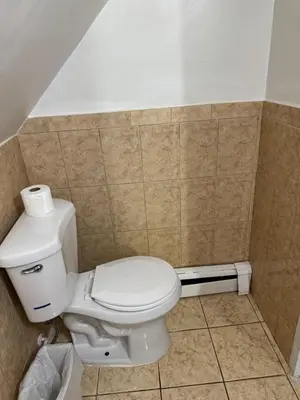 a bathroom with a white toilet in a room at BedRoom with half bathroom in Ridgefield Park