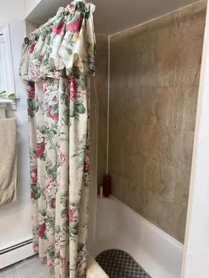 a shower curtain in a bathroom next to a tub at BedRoom with half bathroom in Ridgefield Park