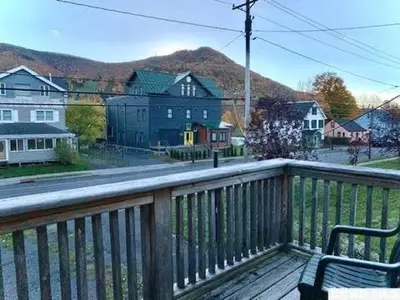 a wooden deck with a bench on a balcony at The Mountain House in Lanesville