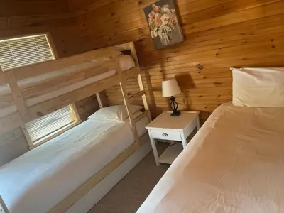 a bedroom with two beds in a log cabin at The Mountain House in Lanesville
