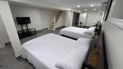 a room with two beds and a television and a staircase at Amazing private single family house in Glendale