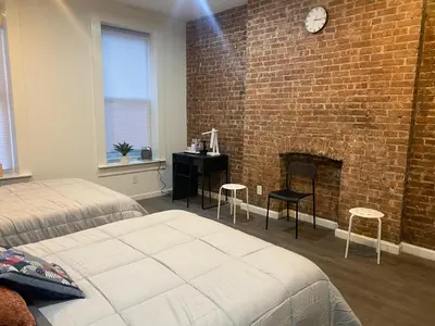 a bedroom with a brick wall and a fireplace at Aycee 417 in New York