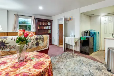 a living room with a vase of flowers on a table at 2 Mi to NYC Train WFH-Friendly Greenwich Apt! in Greenwich