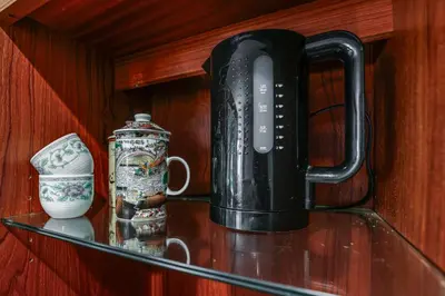 a black appliance sitting on a glass shelf with vases at 2 Mi to NYC Train WFH-Friendly Greenwich Apt! in Greenwich