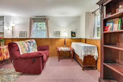 a living room with a red chair and a table at 2 Mi to NYC Train WFH-Friendly Greenwich Apt! in Greenwich