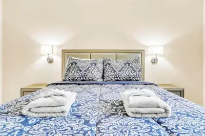 a bedroom with a blue bed with towels on it at TruStay in Central Connecticut in Manchester