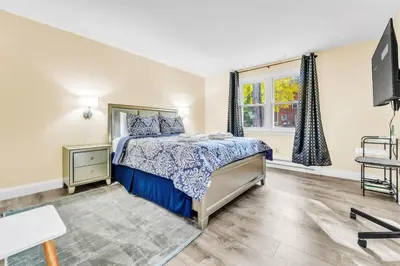 a bedroom with a bed and a tv and a window at TruStay in Central Connecticut in Manchester