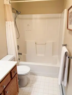 a bathroom with a white tub and a toilet at Mountain Retreat in the Catskills in Roxbury