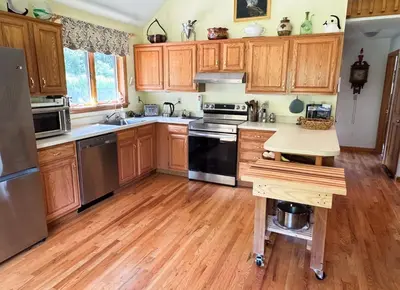 a kitchen with wooden cabinets and stainless steel appliances at Mountain Retreat in the Catskills in Roxbury