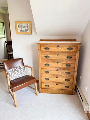 a bedroom with a wooden dresser and a chair at Mountain Retreat in the Catskills in Roxbury