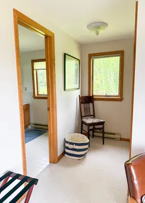 a living room with a chair and a mirror at Mountain Retreat in the Catskills in Roxbury