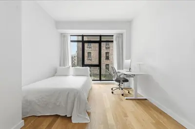 a white bedroom with a desk and a bed at Elegant Studio Apartment in Steinway