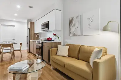 a living room with a couch and a table at Elegant Studio Apartment in Steinway