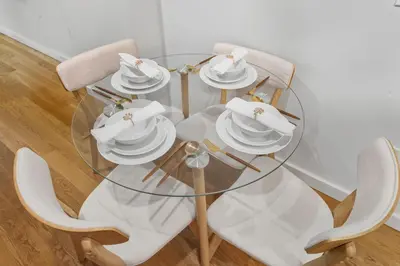 a glass table with white dishes on top of it at Elegant Studio Apartment in Steinway