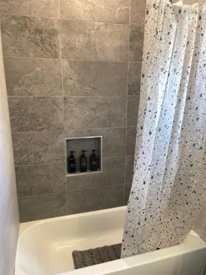 a bathroom with a bath tub with a shower curtain at Peace Sterling Haven in Newark