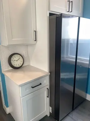 a kitchen with a refrigerator and a clock on a counter at Peace Sterling Haven in Newark
