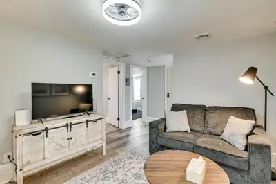a living room with a couch and a tv at 2 Mi to Uptown Centrally Located Kingston Apt! in Kingston