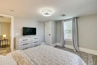 a bedroom with a bed and a dresser with a tv at 2 Mi to Uptown Centrally Located Kingston Apt! in Kingston