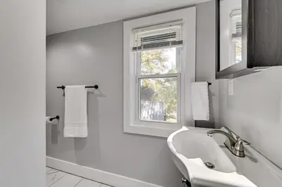 a white bathroom with a sink and a window at 2 Mi to Uptown Centrally Located Kingston Apt! in Kingston