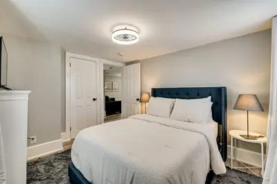 a bedroom with a large bed with a blue headboard at 2 Mi to Uptown Centrally Located Kingston Apt! in Kingston