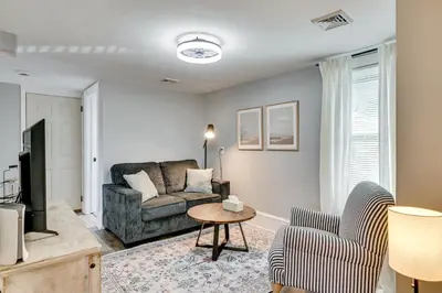 a living room with a couch and a tv at 2 Mi to Uptown Centrally Located Kingston Apt! in Kingston
